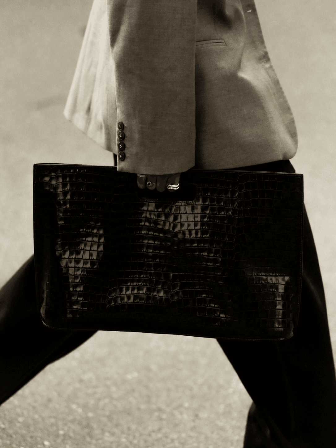Grey tailoring styled with a sculptural black leather bag