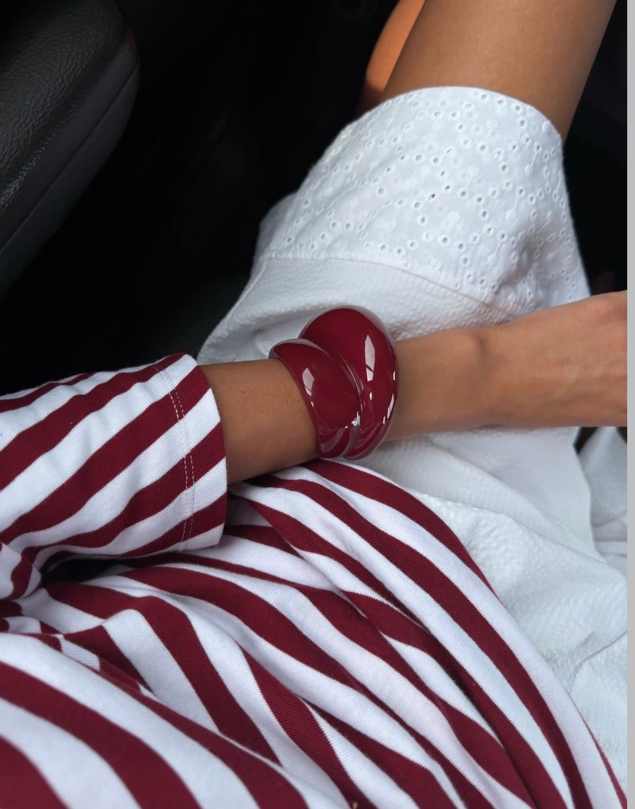 Red striped tailoring styled with sculptural red bangles and white eyelet cotton